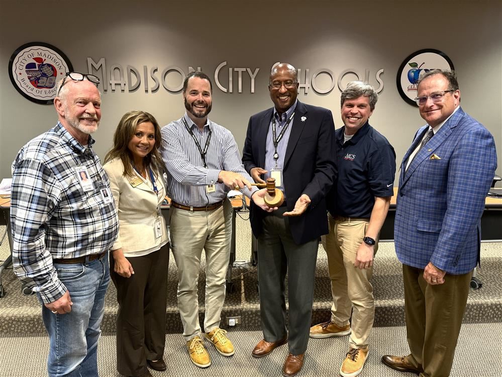  Board surrounding Tim Holtcamp passing gavel to Travis Cummings